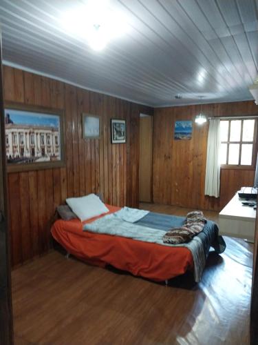 Un dormitorio con una cama en una habitación con paredes de madera. en foresti macedo casa, en Gramado