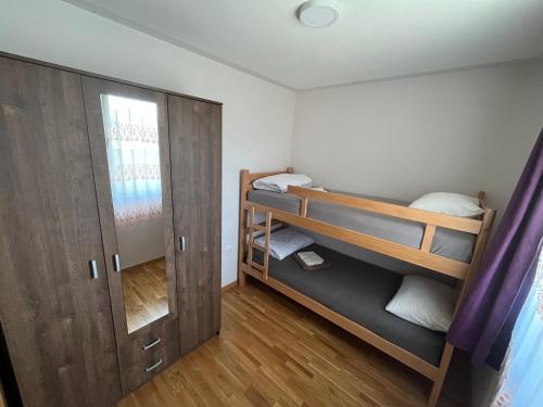 イヴァニツァにあるVila Manaの二段ベッドとドアが備わる小さな客室です。