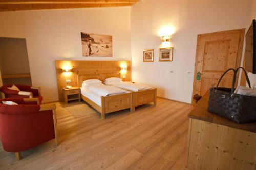 a bedroom with a bed and a desk in a room at Hotel Gran Paradiso in San Cassiano
