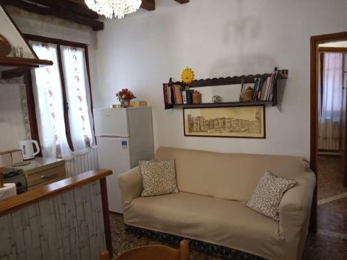 uma sala de estar com um sofá e um frigorífico em Casa Forner, Venezia em Veneza