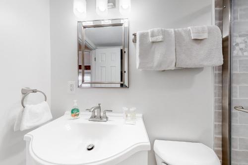 a white bathroom with a sink and a mirror at 14 Clipper on the Bay in Ocean Pines