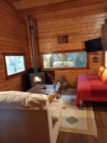 a living room with a fireplace in a log cabin at Veiga Mariña in Pontevedra