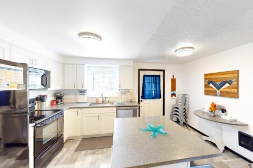 a kitchen with white cabinets and a starfish on a counter at Coastal Calm in Lincoln City