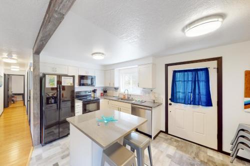 a kitchen with white cabinets and a table at Coastal Calm in Lincoln City