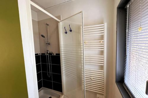 eine Dusche mit Glastür im Bad in der Unterkunft Studio avec accès indépendant: Le 15 Bis in Violaines