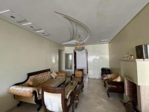 - un salon avec des chaises, un canapé et un lustre dans l'établissement Appart " Haut Standing Marοcain " 120m2 city center, à Tanger