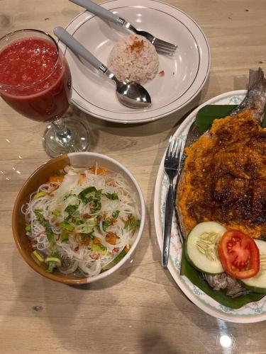 a table with two plates of food and a drink at Toraja Homestay & Coffee Bunna in Rantepao