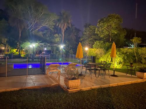 a patio with tables and chairs and umbrellas at night at casa-quinta cerca de corrientes y santa ana in Corrientes