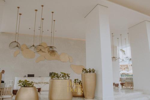 a living room with two large vases with plants at Máritima Golf New apartment private beach access in Nuevo Vallarta 