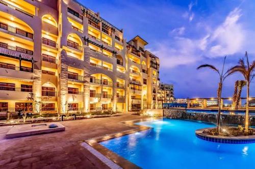 a hotel with a swimming pool in front of a building at الدوهايتس in Hurghada