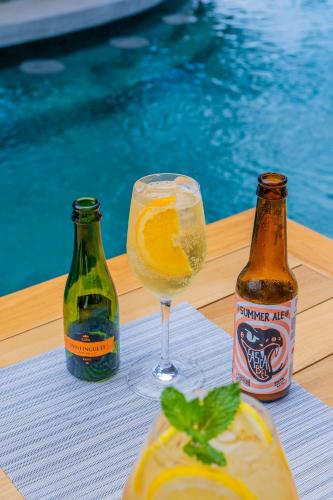 two bottles of beer and a glass of orange juice at Suitree Experience Hotel in Guanacaste