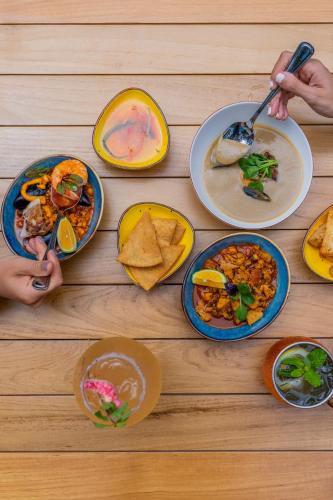 a wooden table with plates of food on it at Suitree Experience Hotel in Guanacaste