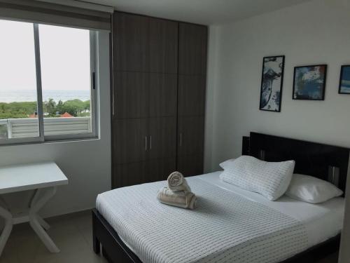 a bedroom with a bed with a desk and a window at Apartamento Duplex con vista al mar in Gaira