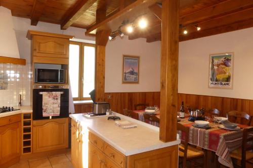 uma cozinha com uma mesa e um fogão forno superior em Gîte des Bruns en chartreuse em Entremont-le-Vieux