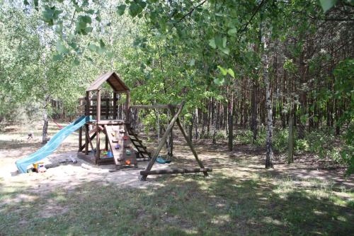 a playground in a park with a slide at Dom imprezowy z noclegami Dziecinów in Dziecinów