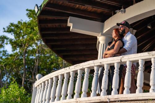 a man and a woman standing on a porch at Hotel Cocoliso Island Resort in Isla Grande