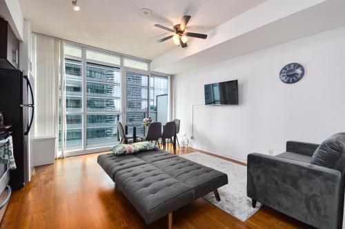 a living room with a couch and a tv at Downtown Toronto condo mins from Scotiabank arena, TIFF, CN TOWER, UNION, MTCC in Toronto