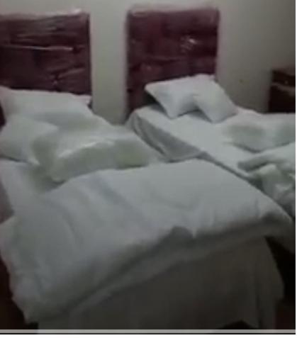um grupo de camas brancas num quarto em غرف مجهزة سكن وتجارة عرعر رجال فقط em Arar