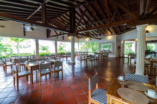 a restaurant with tables and chairs in a room at Hotel Cocoliso Island Resort in Isla Grande