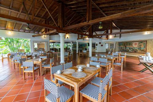 a restaurant with wooden tables and chairs in a room at Hotel Cocoliso Island Resort in Isla Grande
