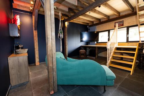 een woonkamer met een blauwe bank en een bureau bij VET - Bed & Breakfast in Beek