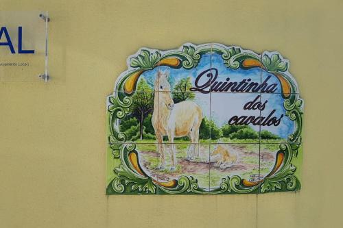 a sign on a wall with a horse on it at Casinha da Lareira - Quintinha dos Cavalos- Arruda dos Vinhos in Arruda dos Vinhos