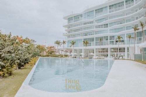 a swimming pool in front of a building at Máritima Golf New apartment private beach access in Nuevo Vallarta 