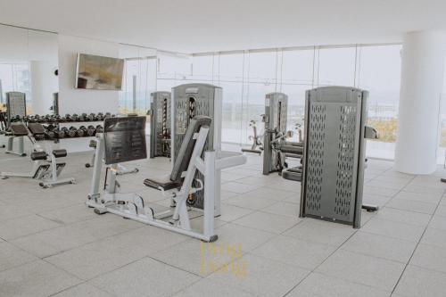 a gym with rows of exercise equipment in a room at Máritima Golf New apartment private beach access in Nuevo Vallarta 