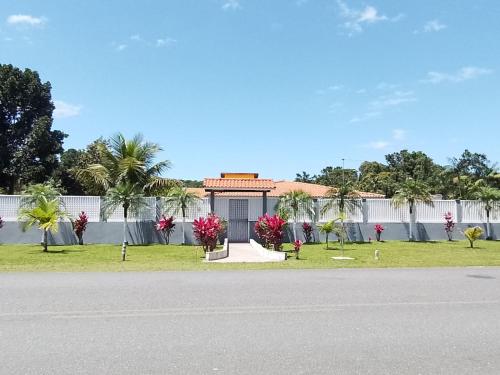 un edificio con flores rosas frente a una calle en Pousada do Alemão exclusiva para pescadores em Cananéia-SP, en Cananéia