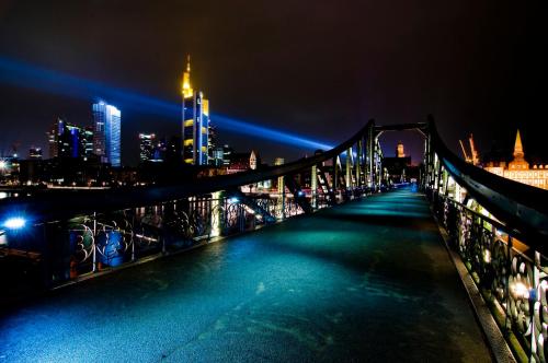 a bridge over a river with a city at night at Holiday Inn Express Frankfurt Airport by IHG in Mörfelden-Walldorf