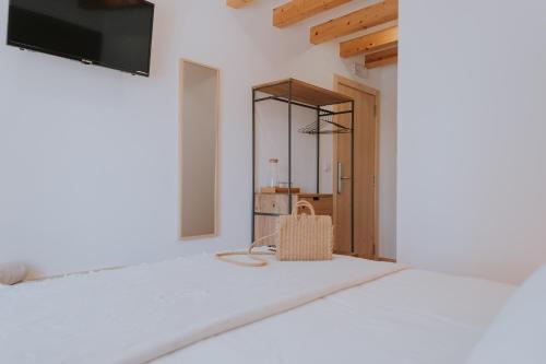 a white bedroom with a bed and a mirror at CasadoRioHotel in Constância