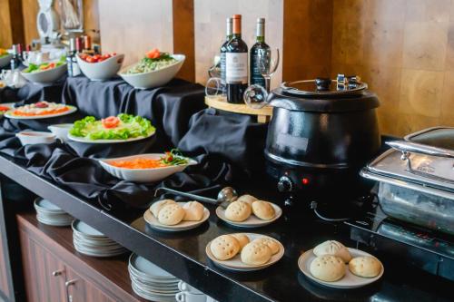 a buffet with plates of food and bottles of wine at Sonesta Hotel Osorno in Osorno
