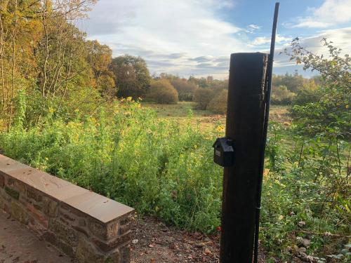a wooden bench sitting next to a field of flowers at Charming stone Bothy at Loch Lomond in Luss
