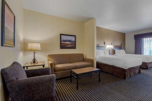 Best Western PLUS Bryce Canyon Grand Hotel في برايس كانيون: غرفة الفندق بسرير واريكة وكرسي