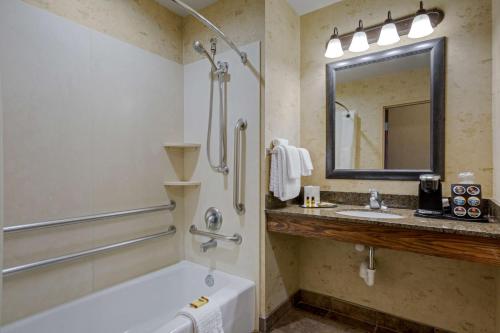 a bathroom with a tub and a sink and a mirror at Best Western PLUS Bryce Canyon Grand Hotel in Bryce Canyon