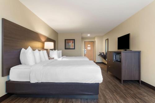 a hotel room with a large bed and a flat screen tv at BEST WESTERN PLUS Saint John Hotel & Suites in Saint John