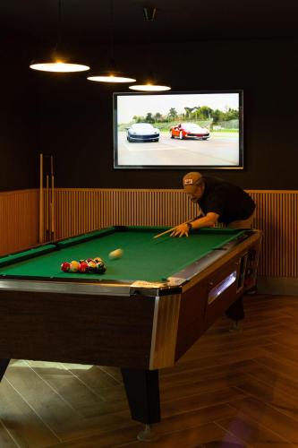 a man in a room with a pool table at Radisson Blu Hotel, Dubai Media City in Dubai