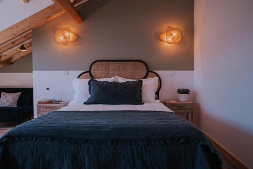 a bedroom with a bed and two lights on the wall at CasadoRioHotel in Constância