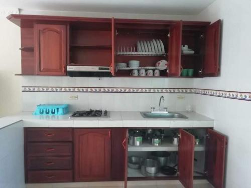 a kitchen with red cabinets and a sink at Acogedora Casa Flandes in Flandes