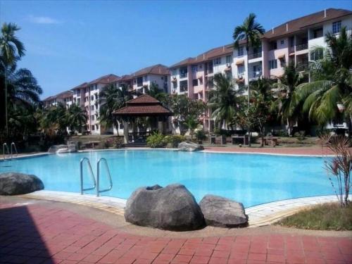 uma piscina com pedras em frente a um edifício em Usrati Homestay by Amirul em Porto Dickson