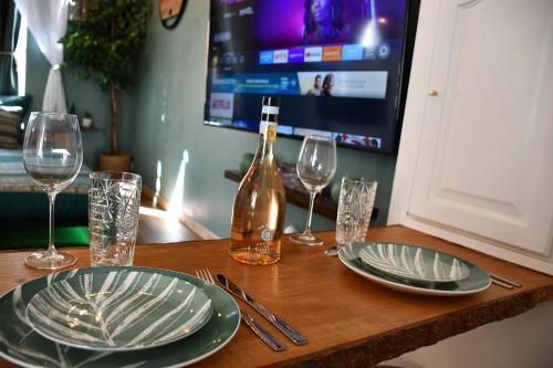 - une table avec des assiettes, des verres et une bouteille de vin dans l'établissement Le Patio H24,Cosy,Port,Plage,Wifi,Netflix, à La Seyne-sur-Mer