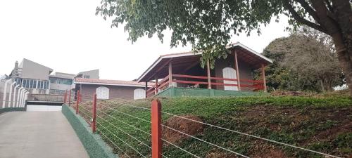 a house on top of a hill with a fence at Casa Campo Bragança in Bragança Paulista