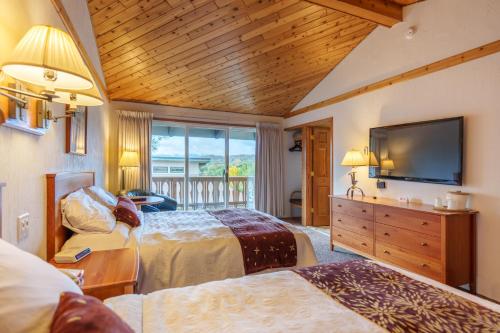 a bedroom with two beds and a flat screen tv at The Devlin in Lake Placid