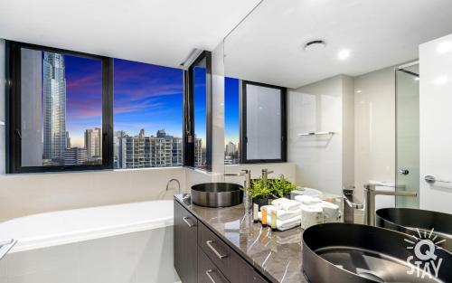 a bathroom with two sinks and a large window at Avalon Apartments - QStay in Gold Coast