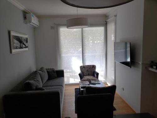 una sala de estar con 2 sofás y una ventana en Departamento Caseros Desing en Salta