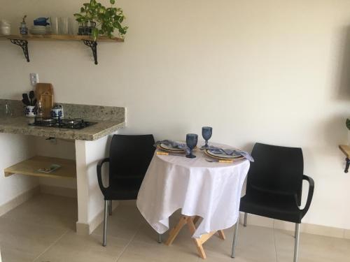 uma mesa com cadeiras e uma toalha de mesa branca em Sua casinha de férias em Icapui CE em Icapuí
