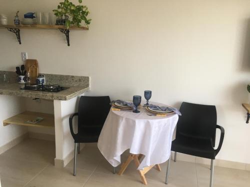 a table with chairs and a white table cloth on it at Sua casinha de férias em Icapui e Tibau in Icapuí