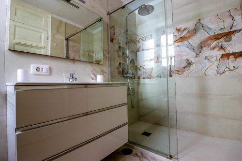 a bathroom with a shower and a sink at Rentaliday Garden Beach in Playa de las Americas