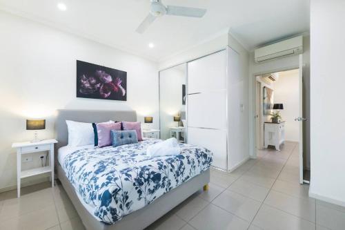 um quarto com uma cama com um edredão azul e branco em Your Keys to Larrakeyah Coastal Comfort with Pool em Larrakeyah