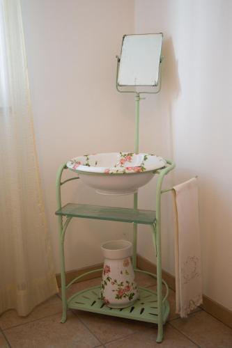 a green stool with a mirror on top of it at Appartamento con giardino e parcheggio privato in Bellagio